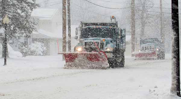 Winter Storm Cuts Power Image of Snowplow in Action