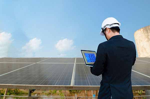 Solar Industry Staggers | Photo of Man Taking Readings on Solar Power