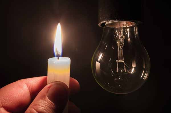 Power Outages | Photo of Person Holding Lighted Candle During Power Outage