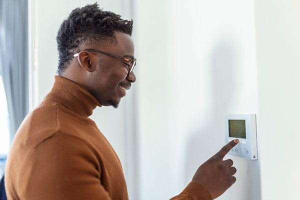Optimize Heating and Cooling Systems Man Turns on Heater