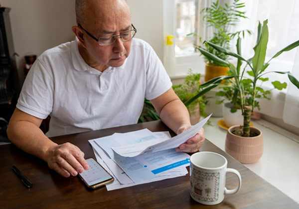 Local Energy Bill Assistance Programs Man Looks at Papers