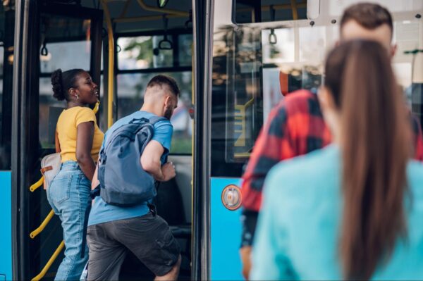 A group of people getting onto a city bus