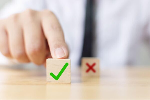 a man with two blocks in front of him, one with a green check ad one with a red x